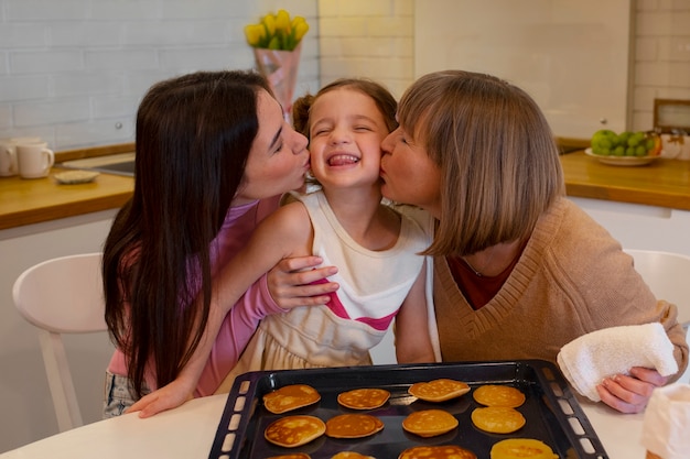 Foto avó sendo beijada na bochecha pela família