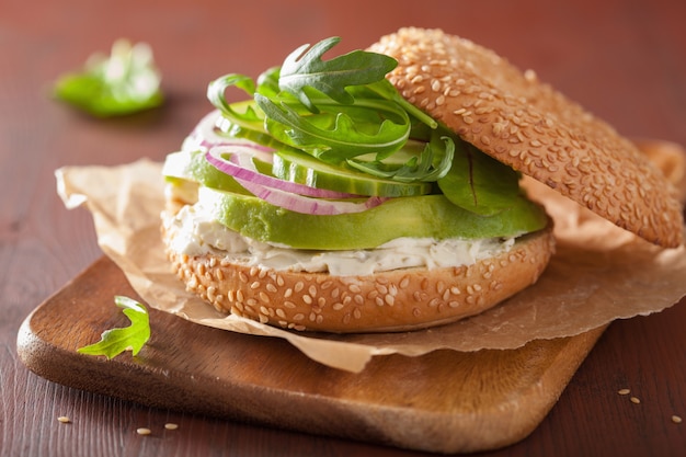 Avocado-Bagel mit Frischkäse, Zwiebeln, Gurken und Rucola