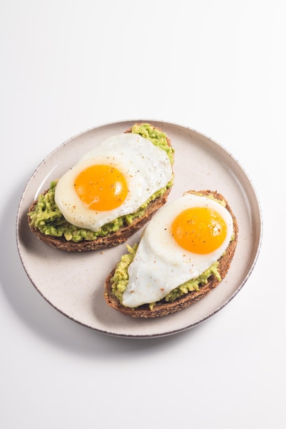 Avocado-Ei-Sandwich mit einem Glas Wasser. Gesundes leichtes Frühstückskonzept. Vollkorntoast mit