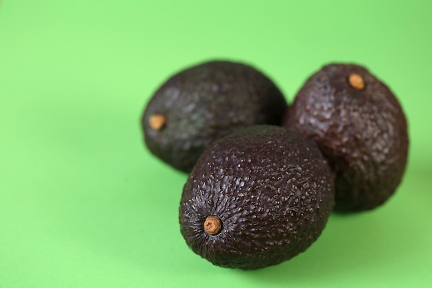 Avocado-Frucht. Drei reife Avocados auf einem hellgrünen Tisch. Nützliches Diätprodukt. Gesundes Fett. Bio Bio frische Avocado