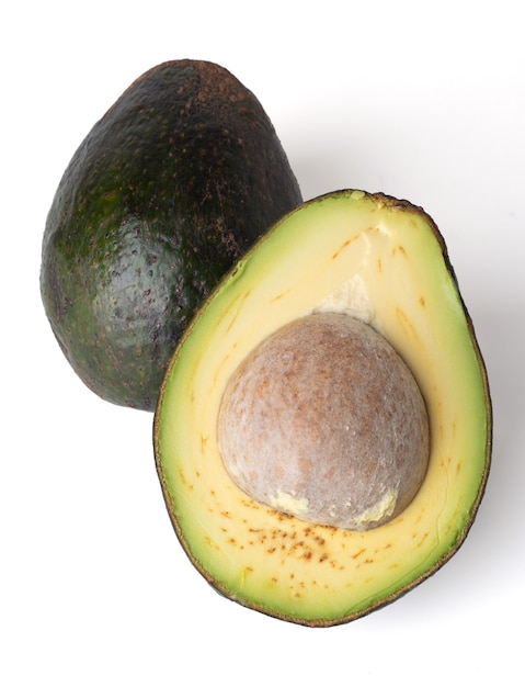 Avocado halbiert isoliert auf weißem Grund, das Fruchtfleisch der Avocado ist cremig und weich mit einem butterartigen Geschmack. Avocados enthalten Nährstoffe, Vitamine und gute Fette.