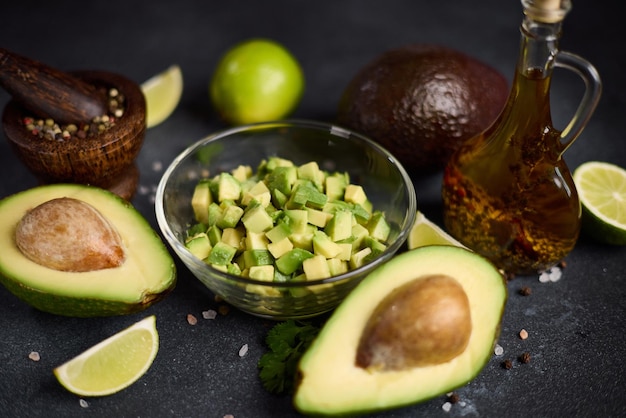 Foto avocado picado numa tigela de vidro e metades de avocado