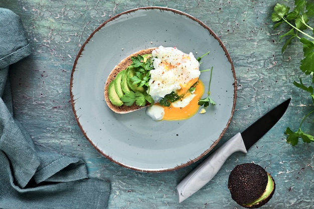 Avocado-Sandwich mit dunklem Brot, geschnittener Avocado und pochiertem Ei,