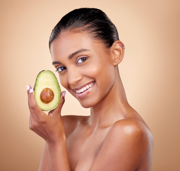 Avocado Schönheit und Porträt einer glücklichen Frau im Studio Hintergrund und ästhetischer Glanz Gesicht des indischen Modells natürliche Hautpflege und Obst für nachhaltige Kosmetika vegane Dermatologie und Gesichtsvorteile