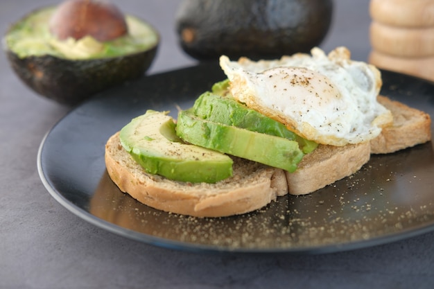 Avocado-Schwarzbrot-Ei und Rosmarin auf dem Tisch