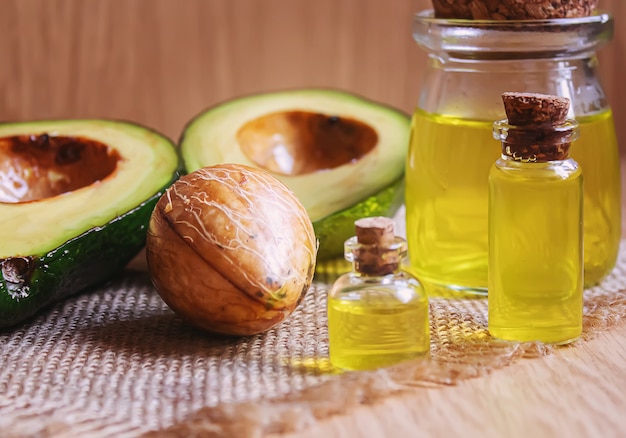 Avocado- und Avocadoöl auf hölzernem Hintergrund. Selektiver Fokus.Essen