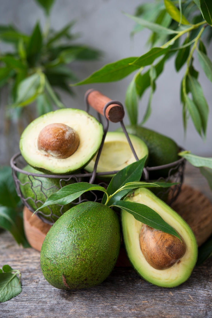 Foto avocado verde fresco com folhas em espaço de madeira