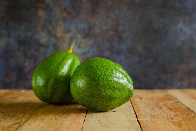 Avocados auf Holztisch. Isolierte Avocados im Vordergrund.