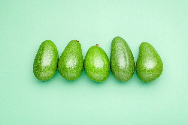 Avocados auf Sommerhintergrundkonzept des Farbhintergrunds.