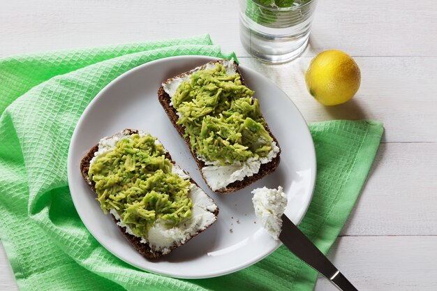 Avocadosandwiche mit Hüttenkäse auf weißer Platte