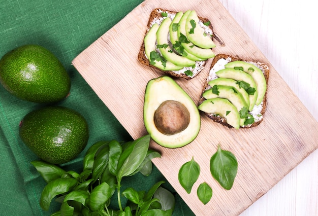 Avocadoscheiben auf einem dunkelschwarzen Zementhintergrund mit Kopienraum für Ihren Menütext