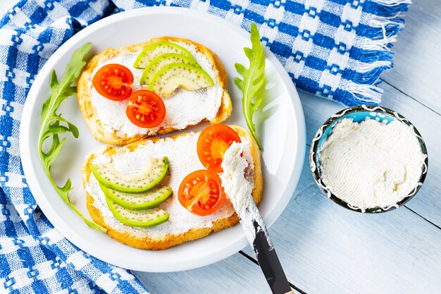 Avocadotoasts mit Frischkäse auf einer weiß-blauen Serviette