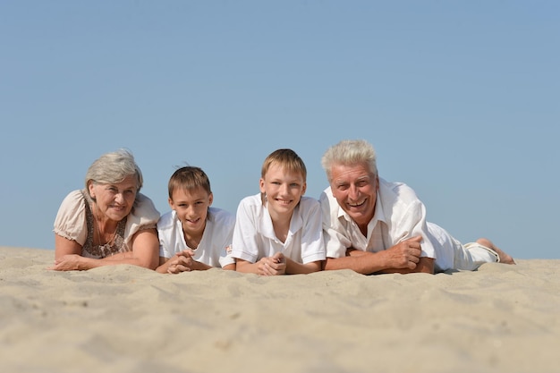 Avós com seus netos descansando na areia