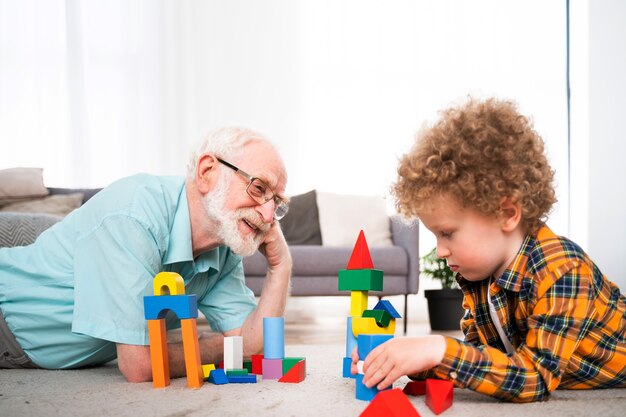 Avós e neto brincando em casa - Família em casa, avô cuidando do sobrinho