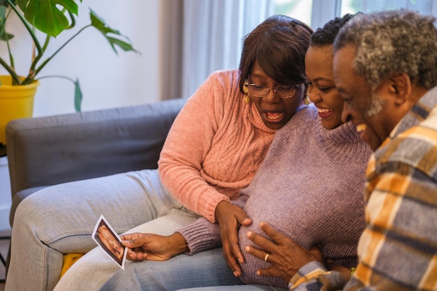 Avós orgulhosos da gravidez de sua filha conversando com outros parentes pela internet Conceito Comunicação de maternidade familiar