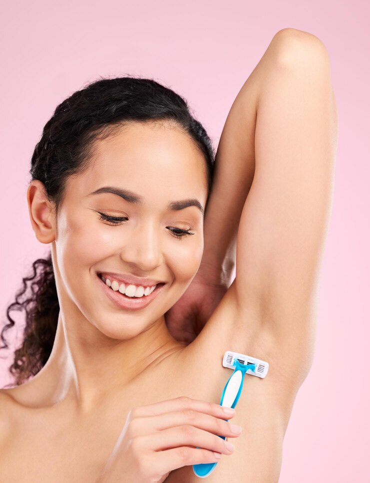 Foto axila feliz e uma mulher se barbeando para depilar beleza e cuidar do corpo em um fundo de estúdio sorria bem-estar e uma jovem ou modelo com uma navalha para cuidados e higiene em um pano de fundo