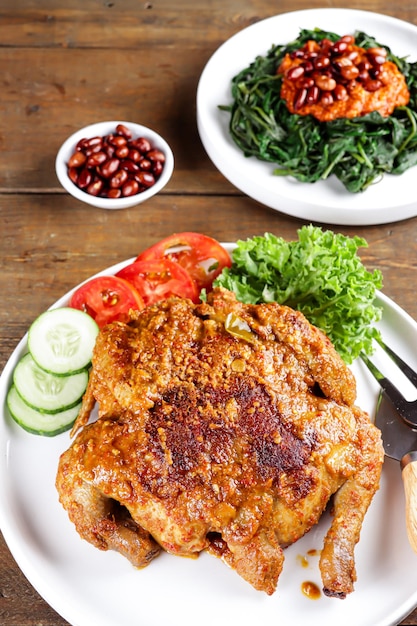 Ayam bakar Taliwang es un pollo asado tradicional de Lombok Indonesia sobre un fondo de madera
