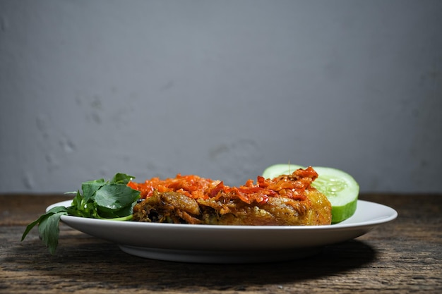 Ayam geprek sambal indonesia food oder geprek frittiertes huhn mit sambal hot chili sauce auf weißem teller