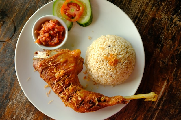 Ayam Goreng. Frango kampong frito indonésio com arroz integral, sambal (molho de pimenta), tomate fatiado.