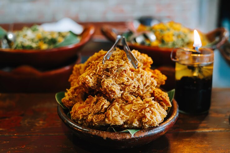 Ayam Goreng Krispi o pollo frito crujiente en el plato de arcilla