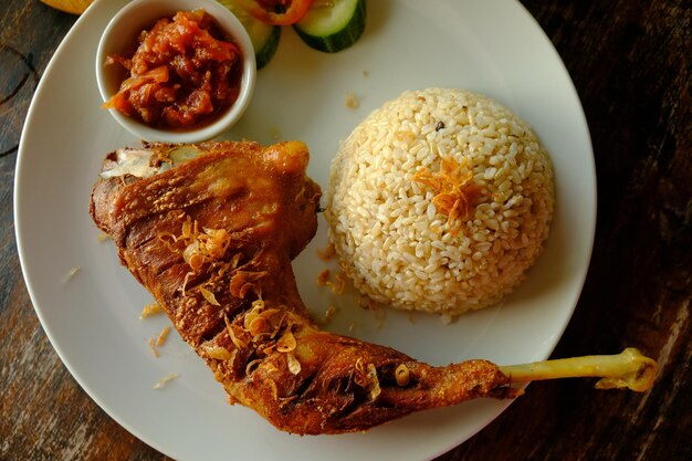 ayam kampung goreng. Brathähnchen mit Naturreis, Sambal und Lalapan. Indonesisches Essen.