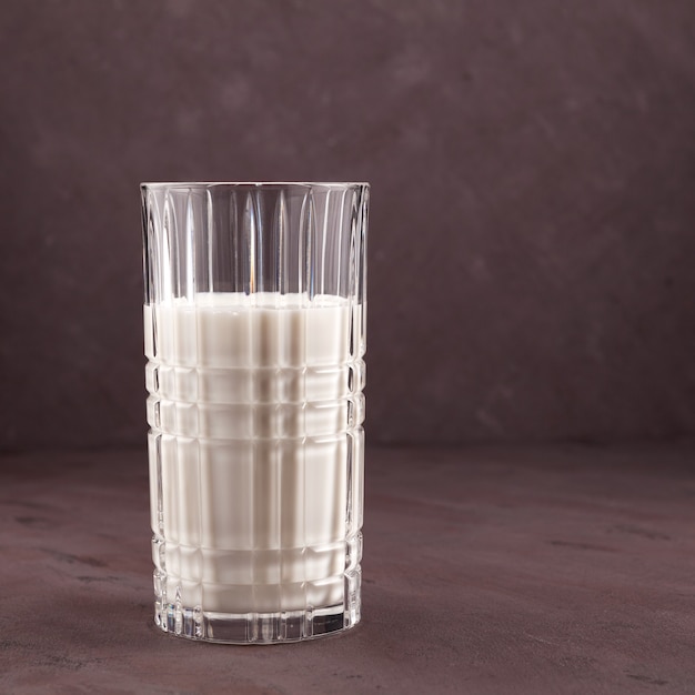 Ayran ou kefir em um copo sobre uma mesa marrom. Bebida láctea fermentada fria probiótica. Dieta com leite para perda de peso.