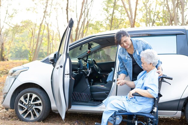 Ayuda y apoyo asiático anciano o anciano anciana mujer paciente sentada en silla de ruedas prepararse llegar a su coche saludable fuerte concepto médico