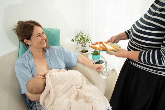 Ayuda de apoyo a la maternidad para comer a la madre joven