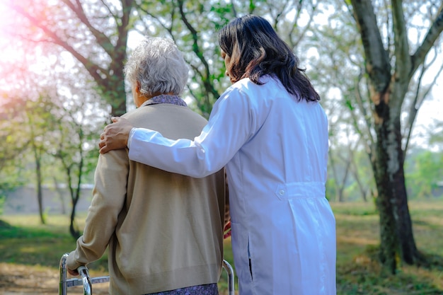 Ayuda y cuidado asiático mayor o anciana anciana mujer uso caminante