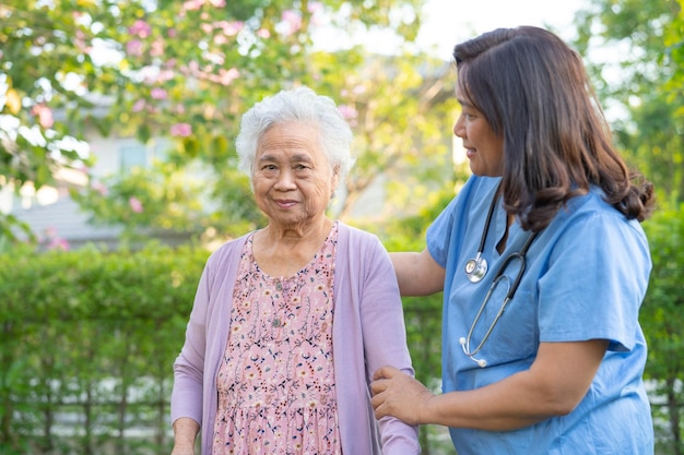 La ayuda y el cuidado del médico Las ancianas asiáticas mayores o ancianas usan un andador con buena salud mientras caminan en el parque en felices vacaciones frescas