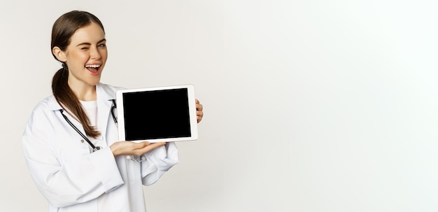 Ayuda médica en línea cita remota sonriente hermosa doctora mostrando la pantalla de la tableta digital