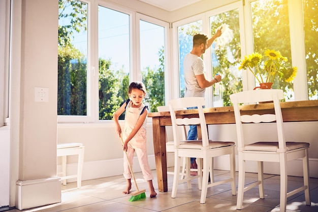 Ayudando a papá con la limpieza de primavera en la casa Fotografía de un padre y su pequeña hija haciendo tareas juntos en casa