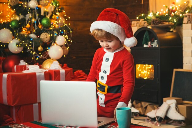 Ayudante de santa usando el cuaderno. Carta de tipo infantil a Santa. Retrato de lindo ayudante de Santa de ensueño