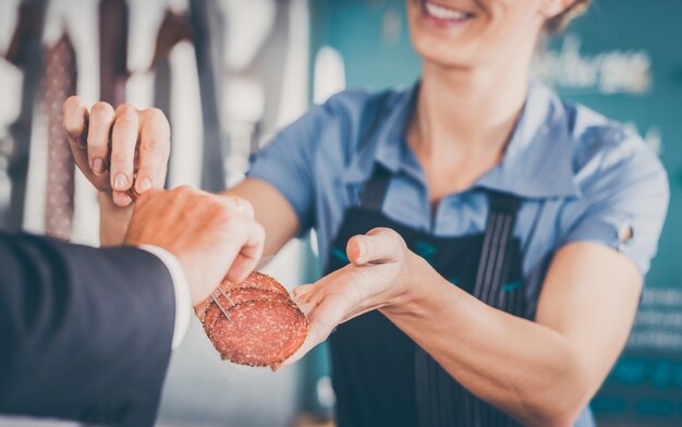 ayudante de tienda dando carne al cliente