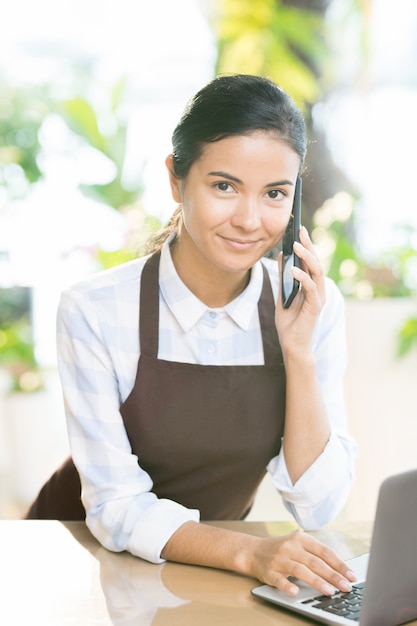 Ayudante de tienda usando teléfono inteligente