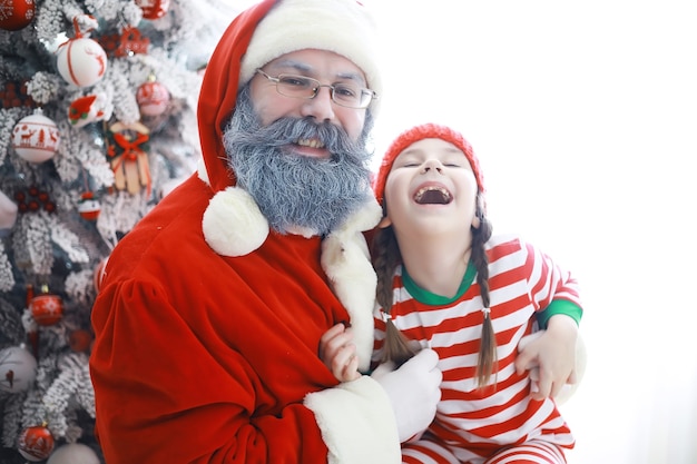 Ayudantes de Santa Claus Lindos niños disfrazados de duende navideño en una habitación bellamente decorada para Navidad. Tiempo de milagros. Regalos de Santa Claus.