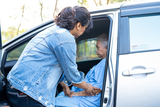 Ayudar y apoyar a la paciente asiática mayor o anciana a llegar a su coche