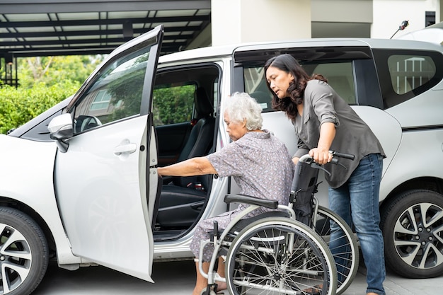 Ayude y apoye a la anciana asiática o a la anciana que se prepara para llegar a su automóvil