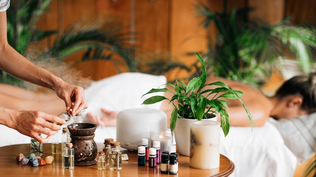 Ayurveda-Aromatherapie-Massage, die aromatisches Öl in einen Diffusor für ätherische Öle gießt