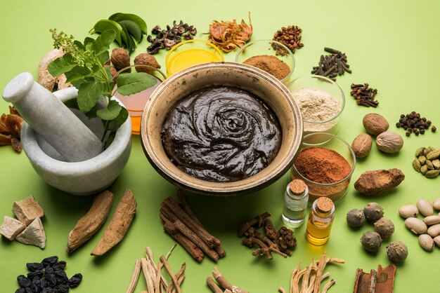 Foto ayurvedic chyawanprash é um poderoso impulsionador da imunidade ou suplemento natural para a saúde. servido em uma tigela antiga com ingredientes, sobre fundo sombrio, foco seletivo