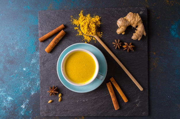 Ayurvedische goldene Kurkuma Latte Milch mit Kurkuma und anderen Gewürzen blau