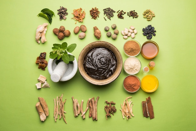 Ayurvedisches Chyawanprash ist ein leistungsstarker Immunitätsverstärker oder ein natürliches Nahrungsergänzungsmittel. Serviert in einer antiken Schüssel mit Zutaten, über stimmungsvollem Hintergrund, selektiver Fokus