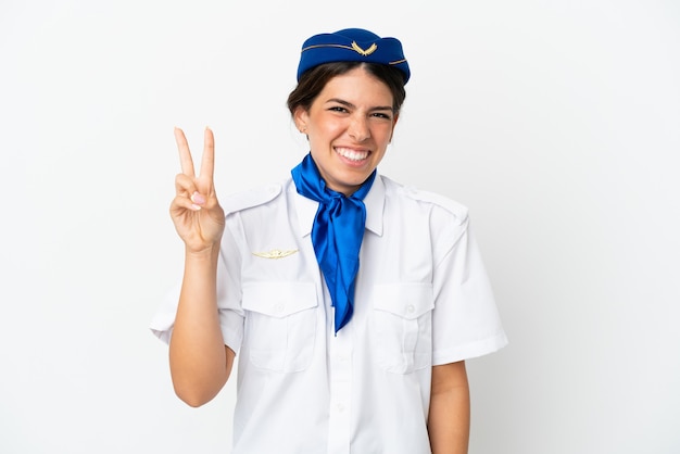 Azafata de avión mujer caucásica aislada sobre fondo blanco sonriendo y mostrando el signo de la victoria