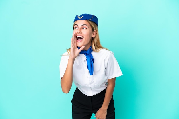 Azafata de avión mujer uruguaya aislada de fondo azul gritando con la boca abierta al lateral