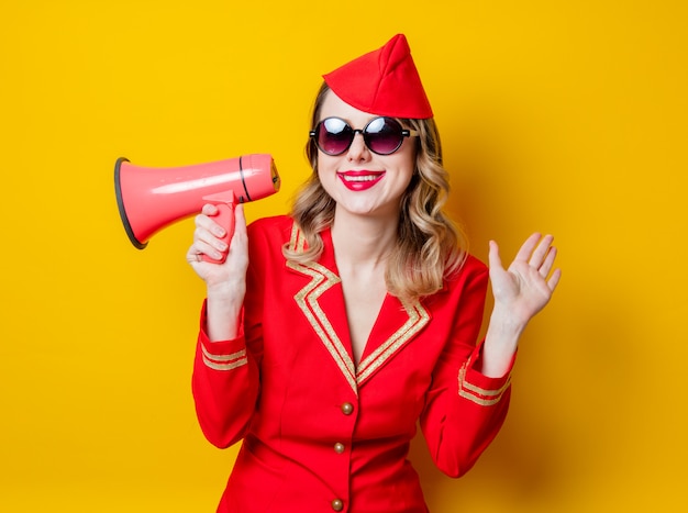 azafata vintage vistiendo en uniforme rojo con megáfono