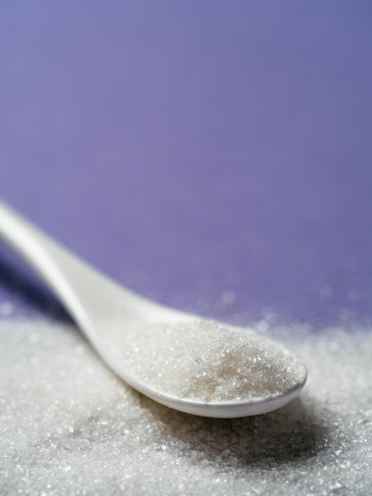 Foto azúcar en cuchara blanca sobre violeta, espacio de copia