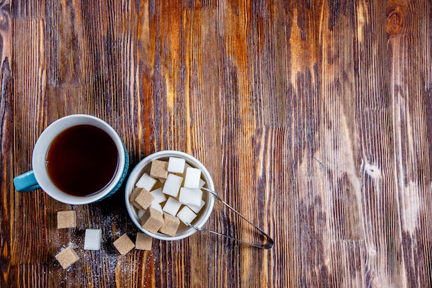 Azúcar marrón y blanco en plato o plato y té en una taza