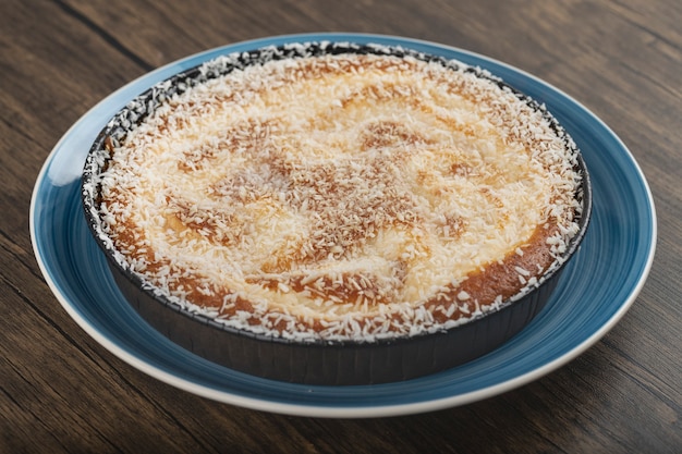 Azul de torta doce com granulado de coco na superfície de madeira