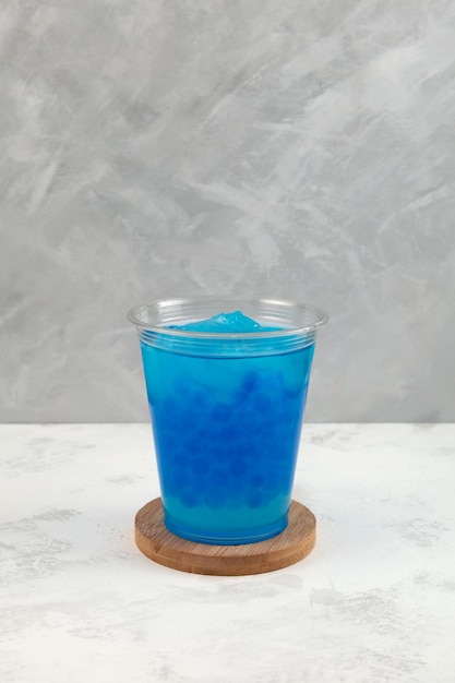 Azul Hielo picado o aguanieve con perlas de tapioca en un vaso de plástico desechable Té de burbujas
