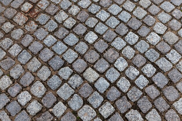 Azulejo asfáltico de forma cuadrada gris. Fotografiado de cerca.